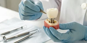 A dentist examines a dental implant model during a continuing education training session.